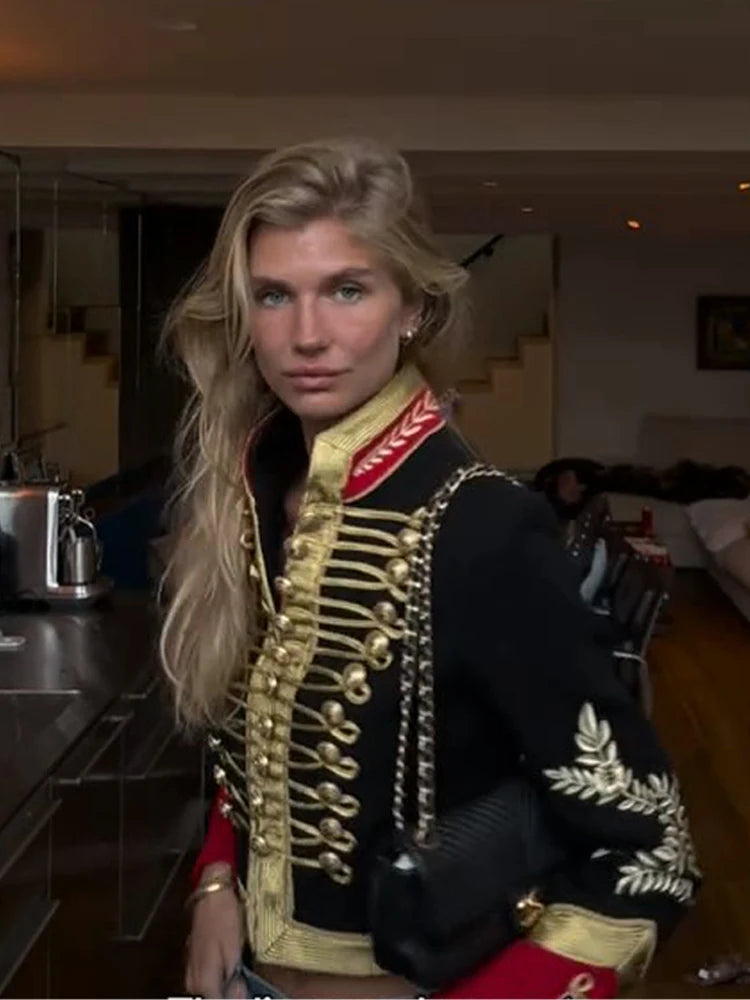 Three-quarter back view of the black military hussar jacket showing the embroidered sleeve motif and red cuff trim