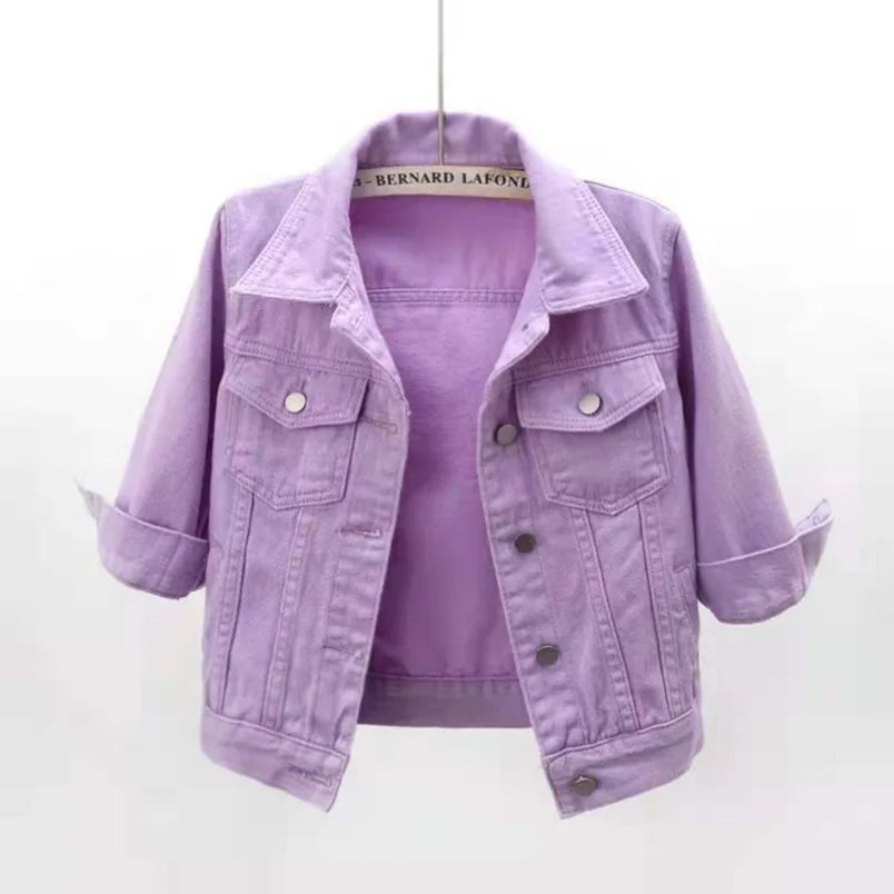 Cropped lavender denim jacket with pointed lapels, chest flap pockets and rolled cuffs, displayed on a hanger