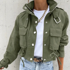 Model wearing the same cropped utility jacket style in solid army green, showing the stand collar, cargo pockets, drawstring hem and buckle shoulder detail